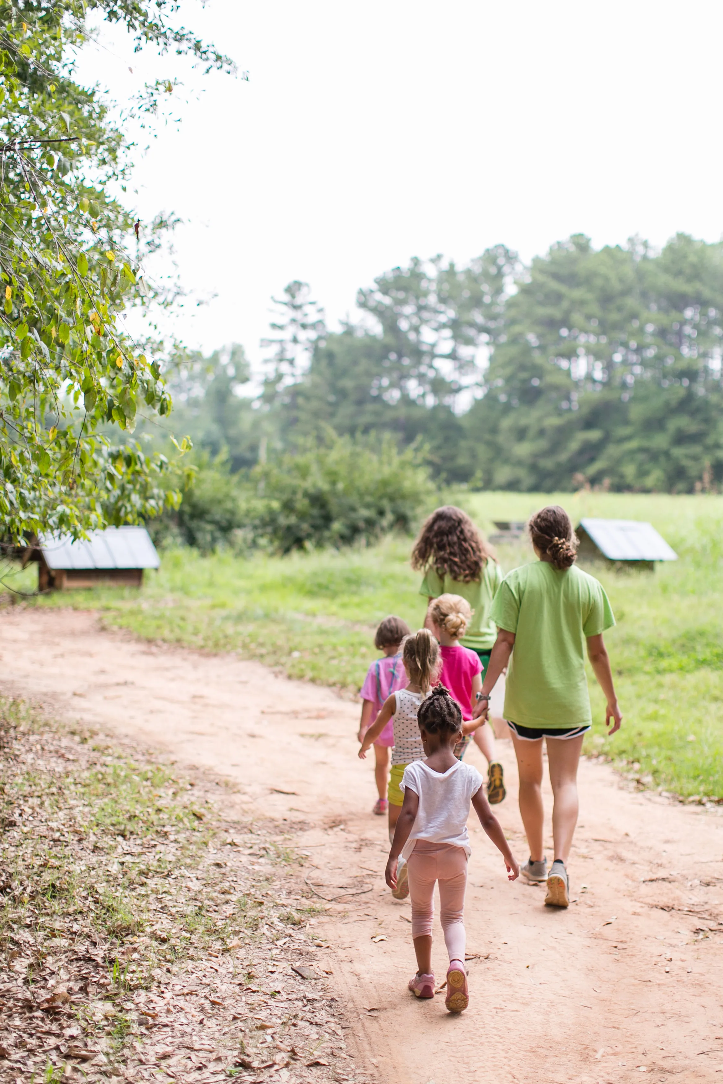 Children walking along a dirt path at Camp Serenbe